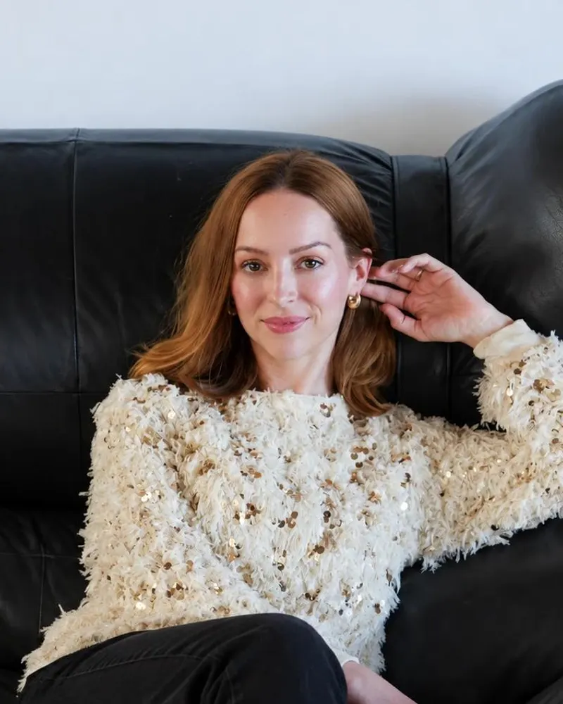 Georgia Austin, founder and CEO of Wordbrew, seated on a black leather sofa