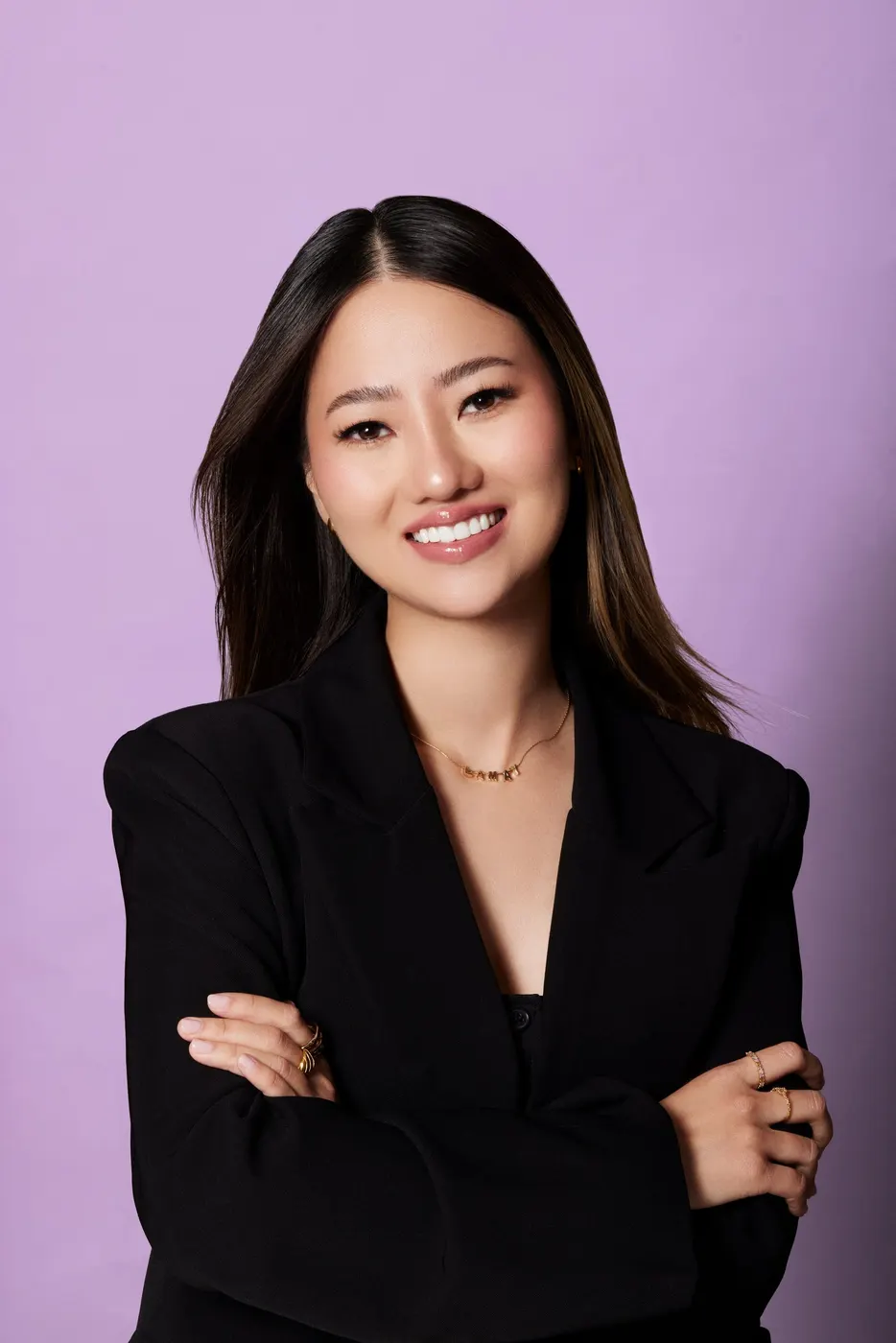 Jenny Truong, founder of DrinkVüi, arms crossed in front of a lilac background
