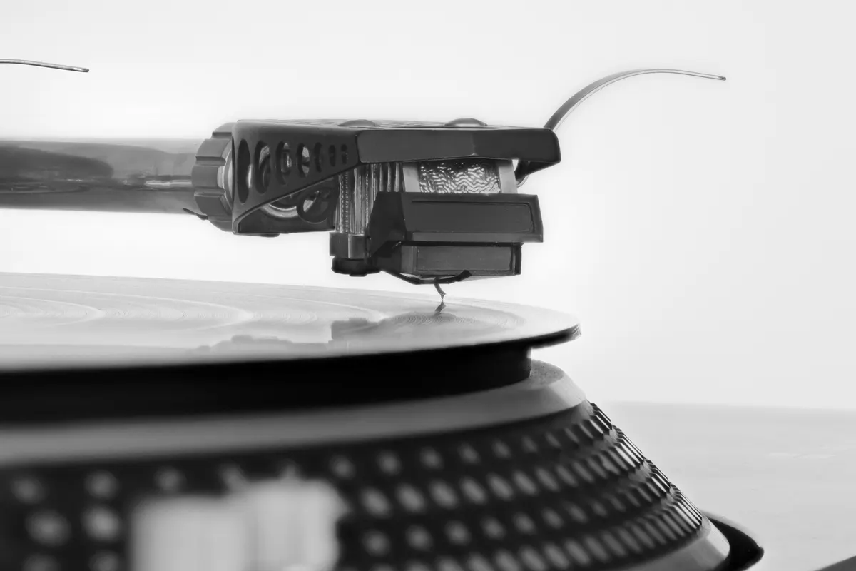 A record player needle resting on the grooves of a spinning vinyl record